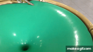 A GIF of a green spiral wishing well. Someone has placed two coins on it, which are now spiraling down the sides of the well towards the bottom, where there's a hole that leads to somewhere we can't see. But we can assume it's some sort of collection box to collect all the coins. The camera adjusts its angle and we see a silver elephant on the edge of the well for decoration.